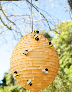 a beehive hanging from a tree with bees on it