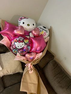 a hello kitty balloon bouquet sitting on top of a couch