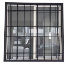 a window that has some bars on the glass and cars in the street behind it