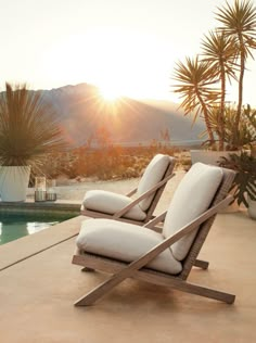 two lounge chairs sitting on top of a patio next to a swimming pool