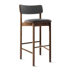 a wooden bar stool with black leather upholstered seat and back rests on a white background