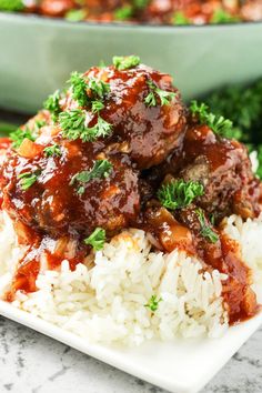 meatballs and rice on a white plate with parsley garnish in the background