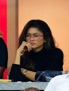 a woman wearing glasses sitting at a table