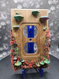 🌿✨ **Transform Your Home with Nature-Inspired Outlet Covers ✨🌿 Looking to bring a touch of magic and whimsy into your space? Check out these handmade **moss-covered wooden outlet covers each uniquely designed with: 🍄 **3D-printed mushrooms**   🐌 **Adorable snails**   💎 **Real crystals** for a mystical vibe! Perfect for fairy garden lovers or anyone wanting to bring a little forest charm into their home. Each cover is lovingly crafted to create a one-of-a-kind piece that blends nature with p Diy Outlet Covers Ideas, Outlet Covers Ideas, Wooden Outlet Covers, Diy Outlet Covers, Healing Decor, Light Switch Art, Business Crafts, Wall Outlet Covers, Mushroom Core