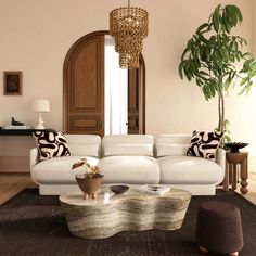 a living room filled with white furniture and a large plant in the middle of the room