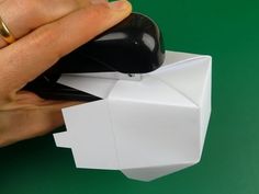 a hand is holding an origami object