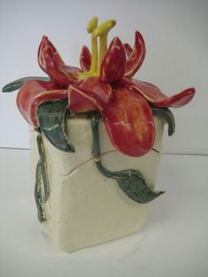 a ceramic vase with red flowers on it