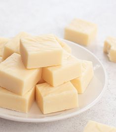 a white plate topped with lots of pieces of butter on top of a marble counter