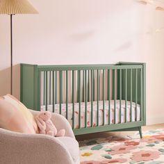 a baby's room with a crib, chair and rug