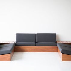 a couch and chair sitting next to each other in front of a white wall on the floor