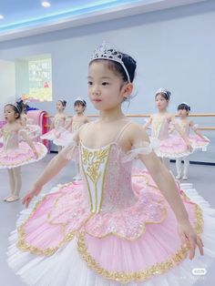 young ballerinas in pink and white tutu with tiaras, posing for the camera