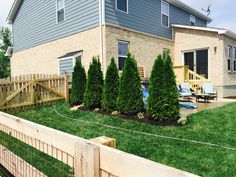 a house that is next to a fence and some grass in front of the house