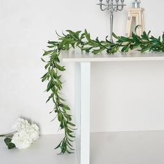 a table with flowers and candles on it next to a candle holder in the shape of a cross