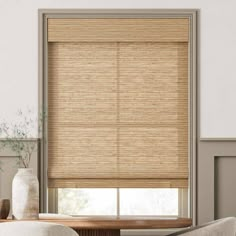 a living room with a couch, chair and window covered in bamboo blind shades on the windowsill