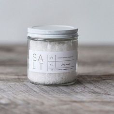 a jar filled with salt sitting on top of a wooden table