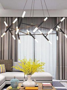 a living room with a couch, coffee table and chandelier hanging from the ceiling