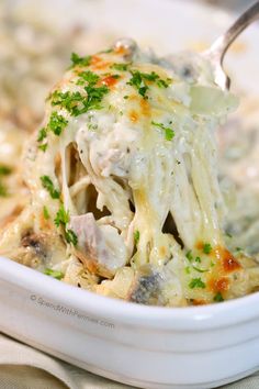 a white bowl filled with pasta covered in chicken and cheese