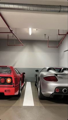 two sports cars are parked in a garage