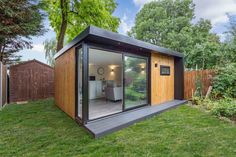 a small backyard office in the middle of a yard with sliding glass doors on it