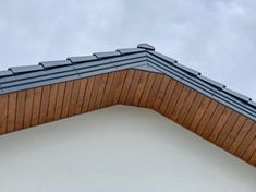 the top of a building with a metal roof and wooden shingles on it's sides