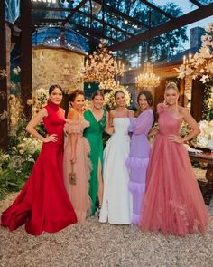 four women in dresses posing for the camera with one woman wearing an evening gown and two are standing next to each other