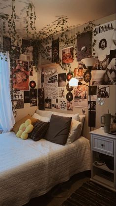 a bed room with a neatly made bed and lots of pictures on the wall above it