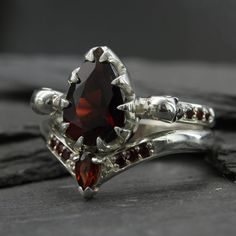 a close up of a ring with a stone in the center and garnets around it