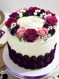 a white cake with purple and pink flowers on it