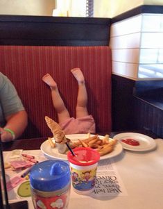 two people sitting at a table with food in front of them