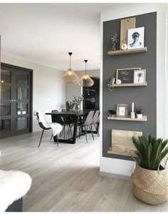 a dining room and kitchen area with wood flooring, gray walls and white furniture