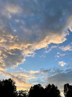 the sky is filled with clouds and trees