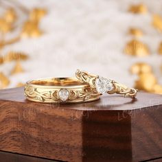 two gold wedding rings sitting on top of a wooden box