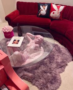 a living room with red couches and a glass coffee table in front of it