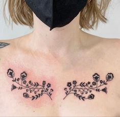 a woman wearing a face mask with tattoos on her chest and behind her is a floral design