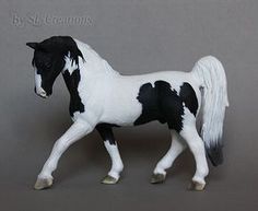 a black and white toy horse on a gray background