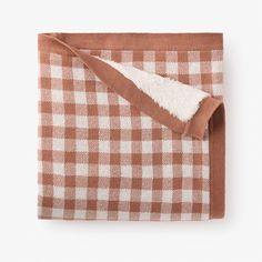 a brown and white checkered blanket folded on top of each other with a pocket