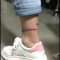 a woman's foot with a small tattoo on the side of her leg,