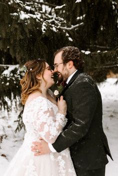 a bride and groom standing in front of a pine tree during their winter elopement