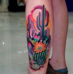 a woman's leg with a cactus and flower tattoo design on the calf area