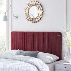 a bedroom with a red headboard and white bedding