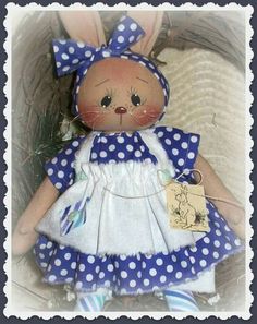 a stuffed animal is dressed in blue and white polka dots