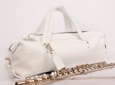 a white bag and flute sitting next to each other