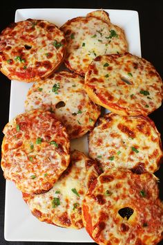 small pizzas are arranged on a white plate