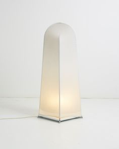 a lamp that is on top of a white tablecloth with a light in the middle