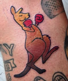 a man with a tattoo on his leg has a kangaroo holding a red boxing glove