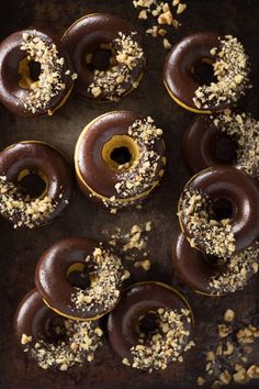 six chocolate donuts with nuts and sprinkles