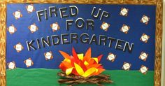 a bulletin board with an image of a campfire and words fire up for kindergarten