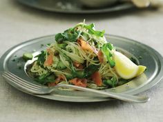 a close up of a plate of food with noodles and veggies on it