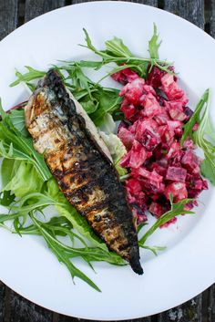 a white plate topped with fish and salad