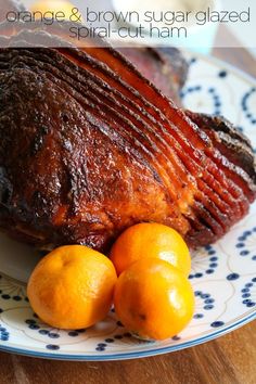 a plate topped with meat and oranges on top of a blue and white plate